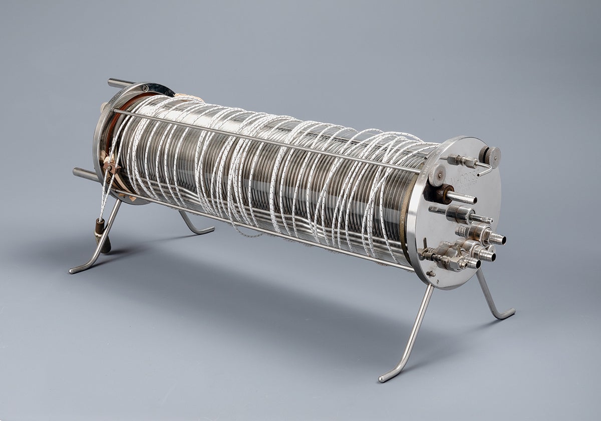 An image of an oxygenator, a component of heart-lung machines. It is a long silver cylinder.