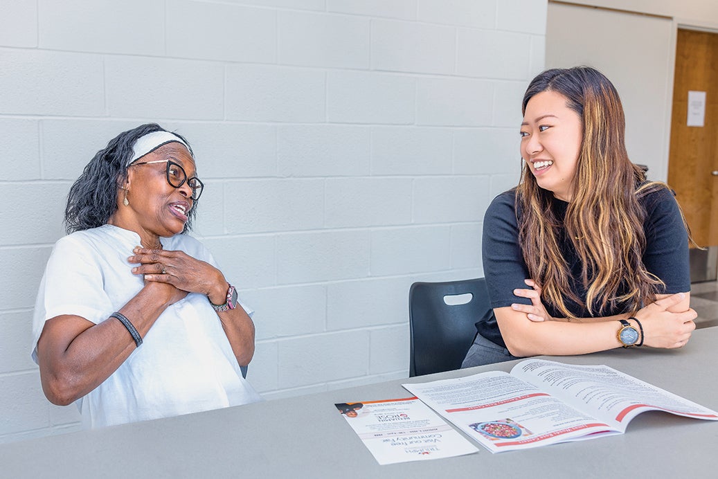 Image of two people happily talking with each other and sitting at a table.