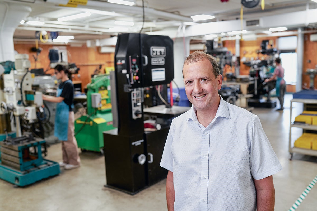 An image of Professor Michael Goldberg standing amid machinery on the fabricating floor of the Larry Sears and Sally Zlotnick Sears think[box] at Case Western Reserve.