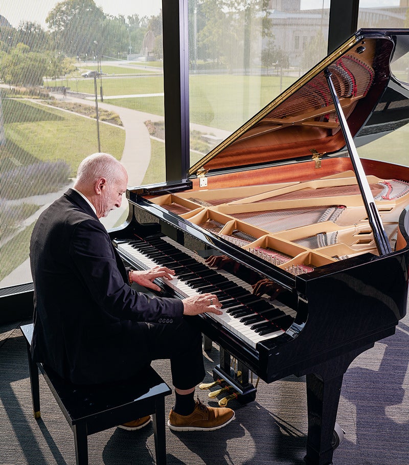 Professor Frank Barrett, who also is a pianist, playing a piano