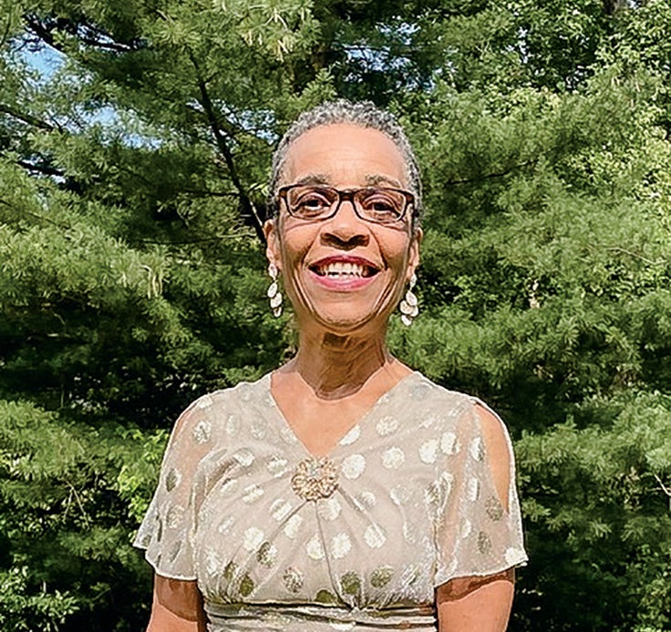 Photo of Linda Berry Wheatt standing outside in front of trees