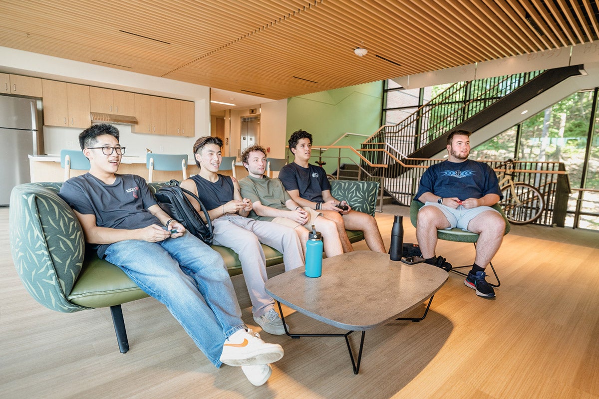 Five students in a residence hall sitting in a lounge.