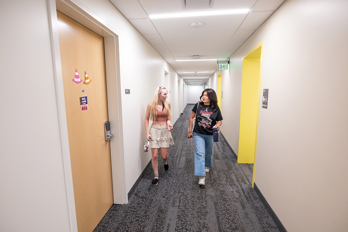 Photo of 2 students walking in a hallway in their new residence hall.