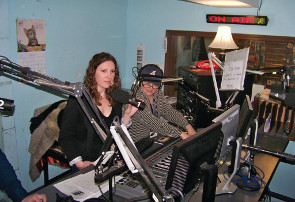 A man and a woman sitting in front of sound equipment.