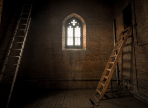 Dark room with a single window and two ladders leaning up towards the ceiling