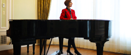 Geri Presti standing beside a piano