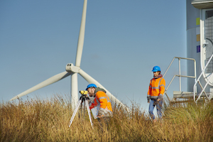 Image of people standing in front of a wind turbine