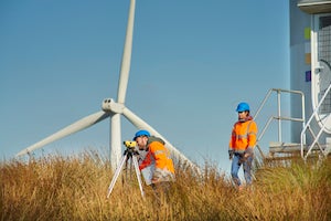 Image of people standing in front of a wind turbine