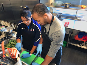Olympic team trainer Alicia Kendig works in a kitchen with an athlete