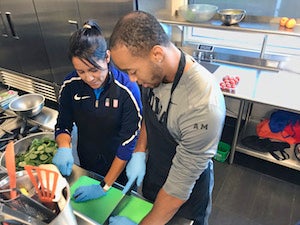 Olympic team trainer Alicia Kendig works in a kitchen with an athlete