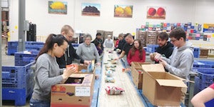 Case Western Reserve University students prepare food on an assembly line