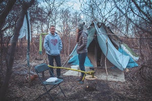 A female Case Western Reserve University student talks with a man in front of a tent shelter in Cleveland