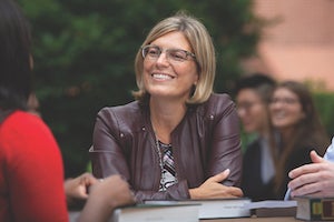 Jessie Hill, JD, sitting with arms folded and smiling