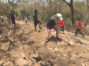 Several Case Western Reserve students using shovels to help install a water pipeline in Costa Rica