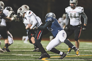CWRU football player, Cameron Brown, making a tackle against a Carnegie Mellon player