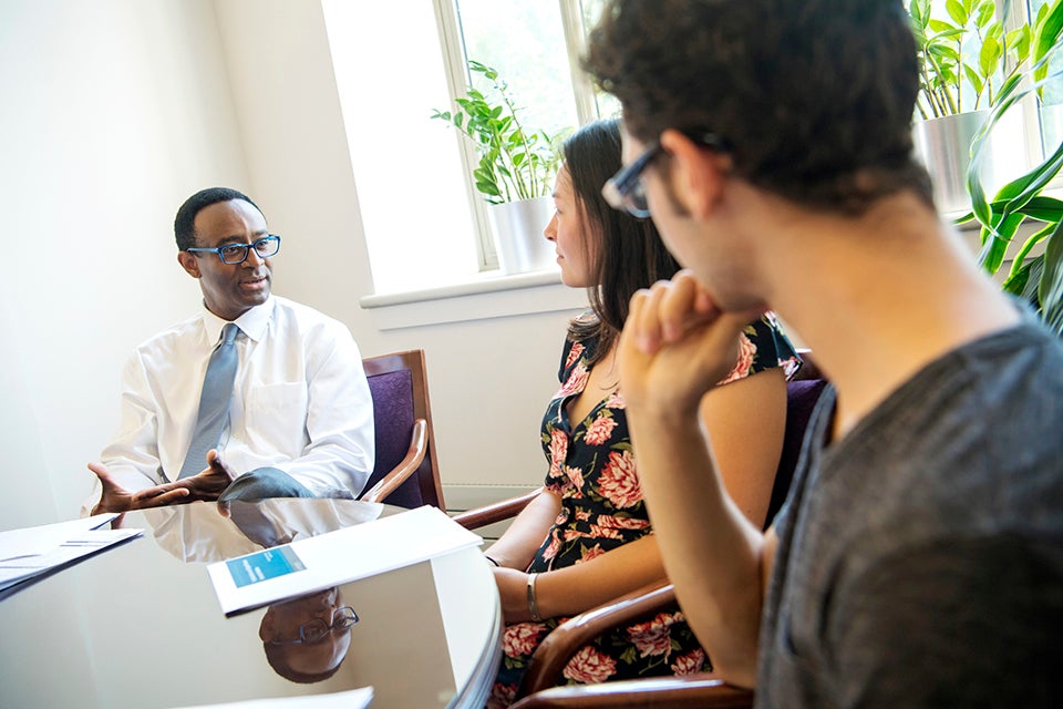 Provost Ben Vison II sitting with two members of the community