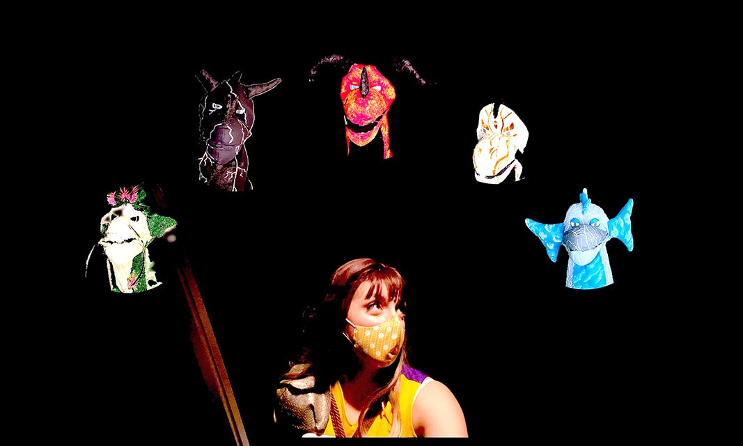 Image of woman wearing a mask surrounding by puppets.