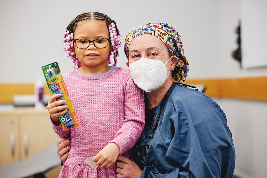 A dental resident and next to a young girl with glasses.