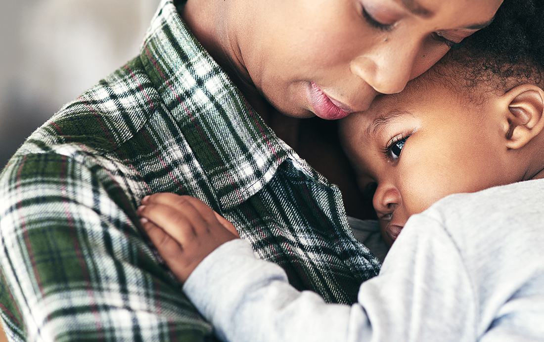 A woman cuddling with a young child.