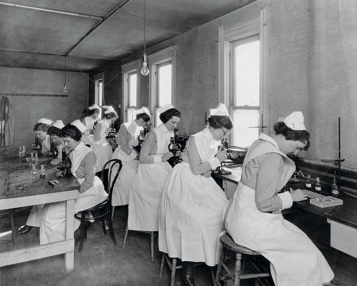 Photo of a row of nursing students working in a campus lab in the 1920s.