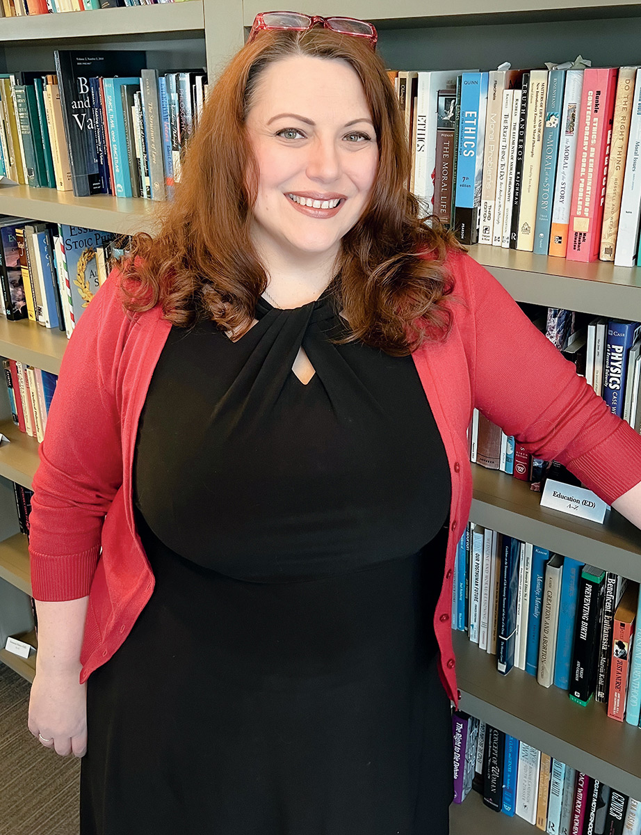 Shannon French standing in front of a bookshelf