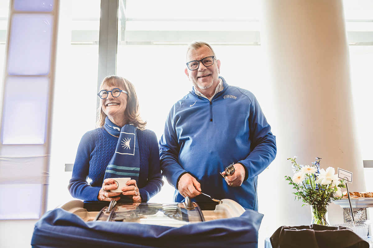 Mr. and Mrs. Kaler smile while holding bicentennial merch