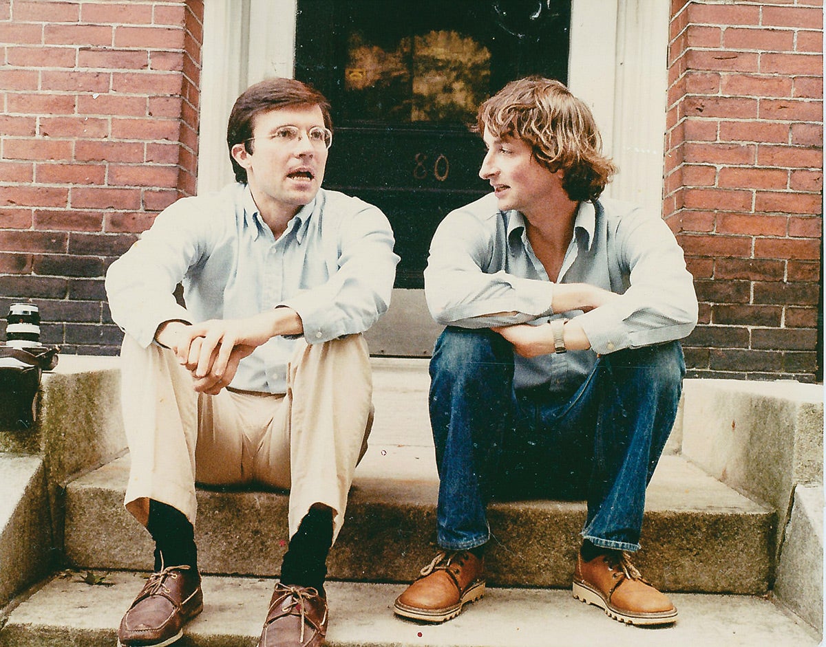Young Terrence Sejnowski and Geoffrey Hinton sitting on a stoop and talking
