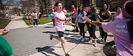 Student participating in Hudson Relays passing the baton to the next runner