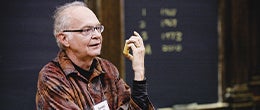 Donald Knuth talking in front of a blackboard