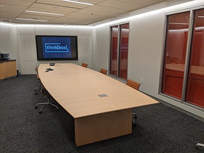 Interior of the conference room with a tv, desk and chairs