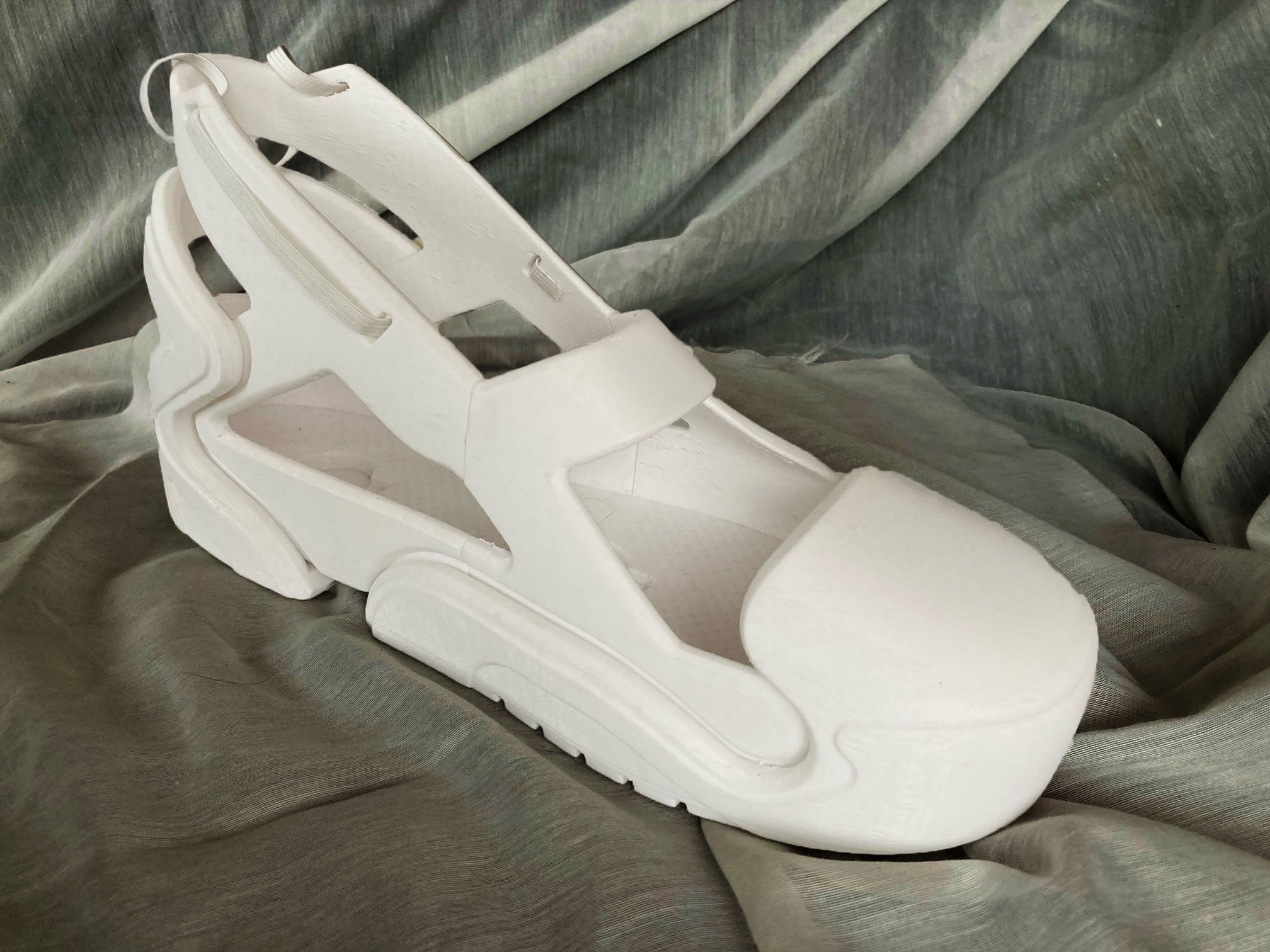 A 3D printed prototype of a modular shoe sits on gray fabric
