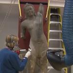 A restoration specialist works on the Cleveland Krishna sculpture