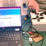 A student demonstrates a custom xbox controller with a laptop