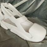 A 3D printed prototype of a modular shoe sits on gray fabric