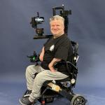Aurelian Barber poses with his robotic arm and wheelchair