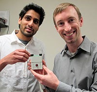 Two men holding a medical device 