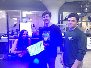 Three students in front of their light therapy device