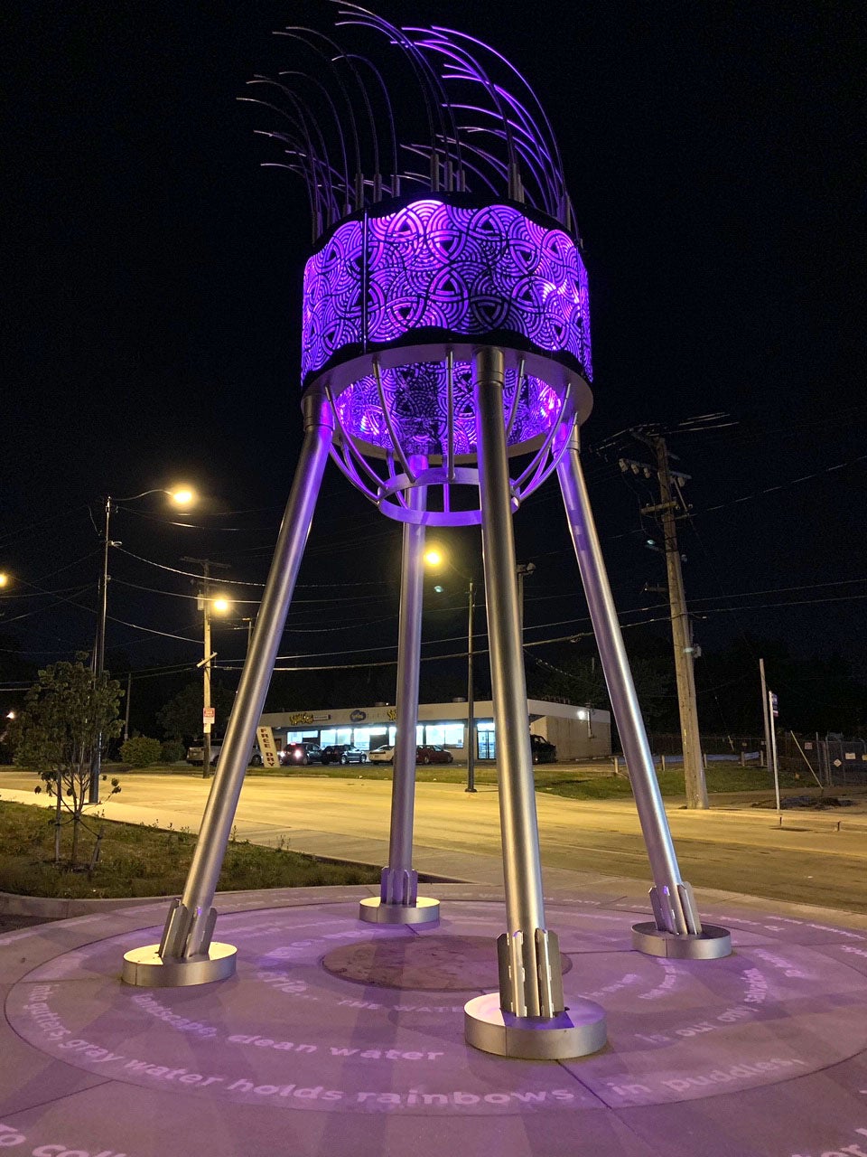 A water tower illuminated by purple light
