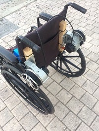 A wheelchair sitting on a cobblestone road