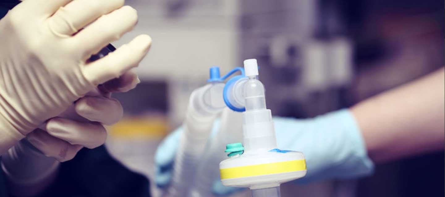 gloved hands holding a ventilator