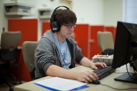 Case Western Reserve University student using a computer with headphones on
