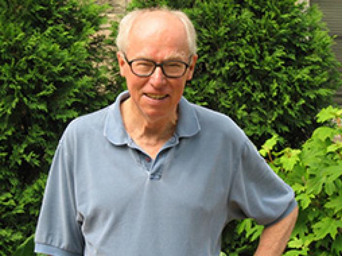 Jim Zull standing in front of summer foilage