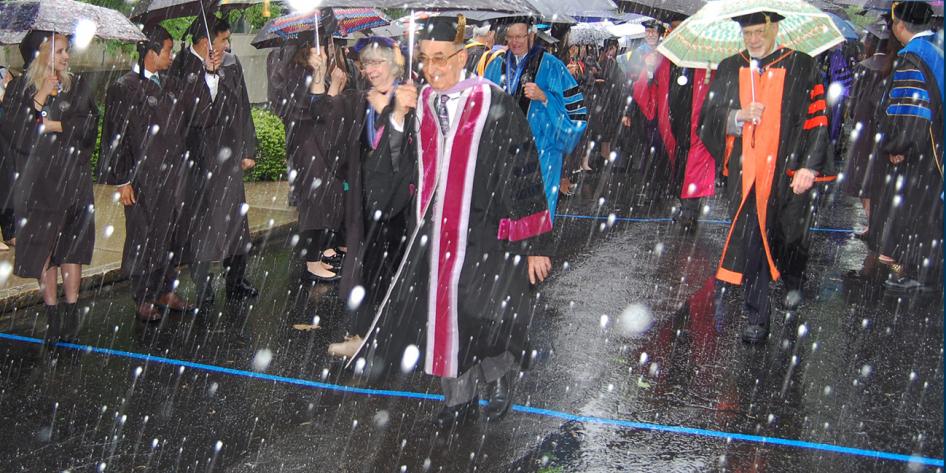 Case Western Reserve University Commencement 2016 staff and graduating students walking with umbrellas in snow