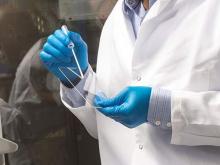 Person in lab coat creating slide