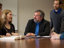 Professor and students sitting around a table