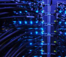 Blue lit inside of a server cabinet with wires extending from server to server