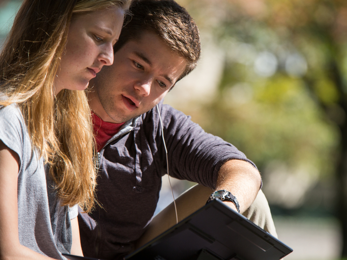 Two students looking at a computer together