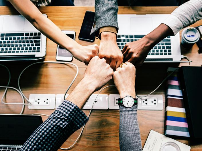 Shared Team Fist bump over computers
