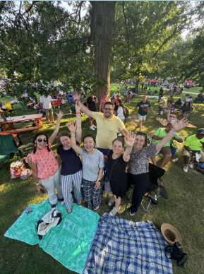 A group of people smiling for a picture in a park.
