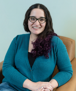 White woman wearing glasses smiling